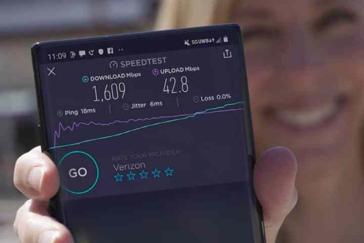 زنی که تلفن هوشمند با نتایج تست سرعت شبکه Verizon 5G Ultra Wideband را در دست دارد.