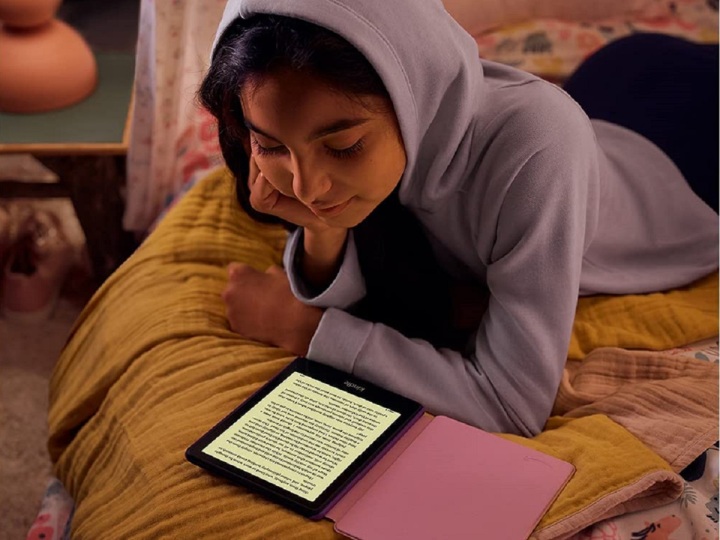 دختری در حال خواندن کتاب الکترونیکی در Amazon Kindle Paperwhite Kids.
