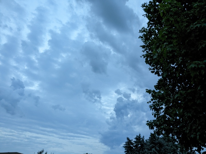 آسمان طوفانی با ابرهای دقیق.  یک تکه چوب در گوشه سمت راست نمایان است.
