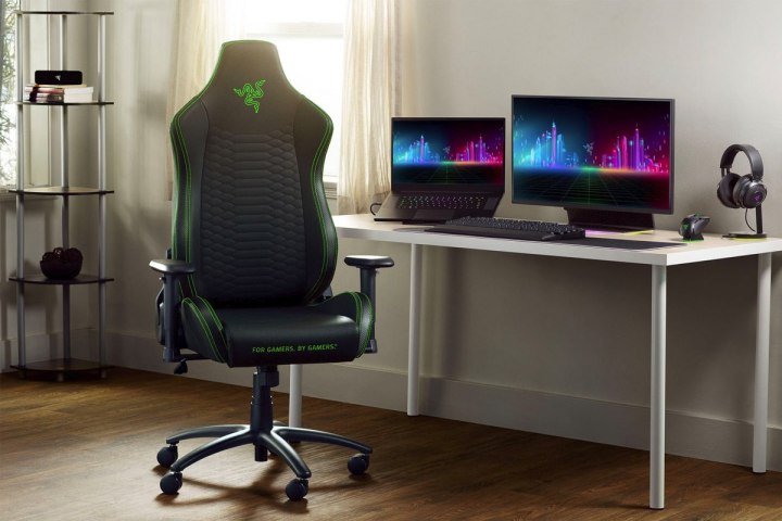 صندلی بازی Razer Iskur X در کنار کامپیوتر و لپ تاپ مخصوص بازی قرار دارد.