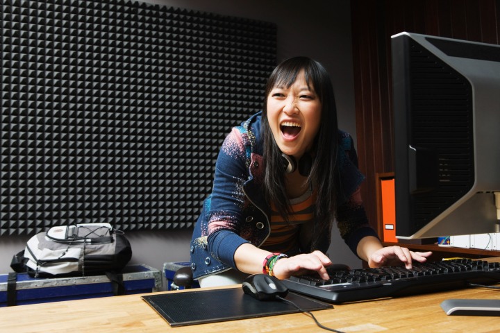 زنی که از خوشحالی در حال انجام بازی های رایانه ای فریاد می زند.