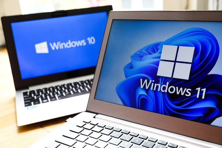 لوگوی سیستم عامل ویندوز 11 و ویندوز 10 بر روی صفحه نمایش لپ تاپ نمایش داده می شود.