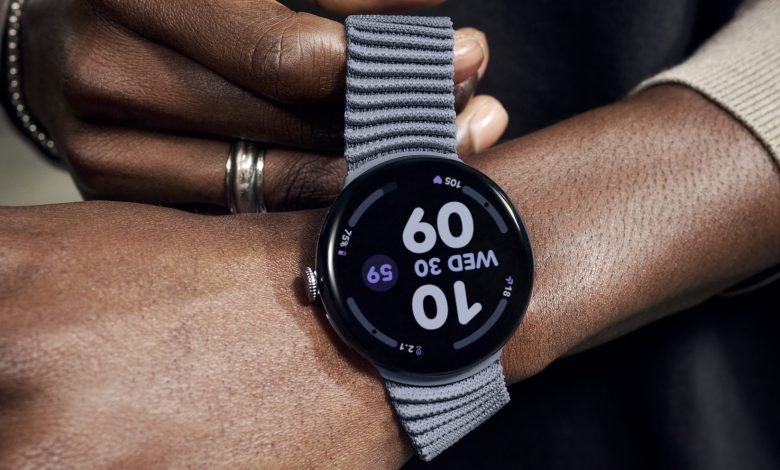 A hand pulling the stretchable strap on the Pixel Watch 4